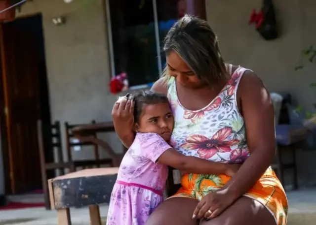 Une femme en train de cajoler un enfant.