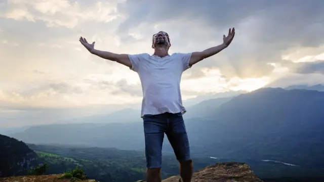 Un homme lève les bras au ciel