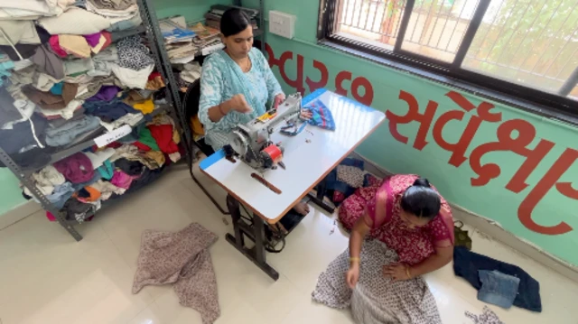 આરઆરઆર સેન્ટર સેલ્ફ હેલ્પ ગૃપની મહિલાઓ થેલી સીવવા અને કાપડનું કટીંગ કરવા આવે છે.
થેલી સીવડવવા આવેલી મહિલાઓ થેલી સીવતા પારુલ બહેન સાથે વાત કરી રહ્યા છે. માય થેલી યાદોની થેલી અમદાવાદ બીબીસી ગુજરાતી જૂના કપડાં પ્લાસ્ટિકનું પ્રદુષણ પ્રદૂષણ