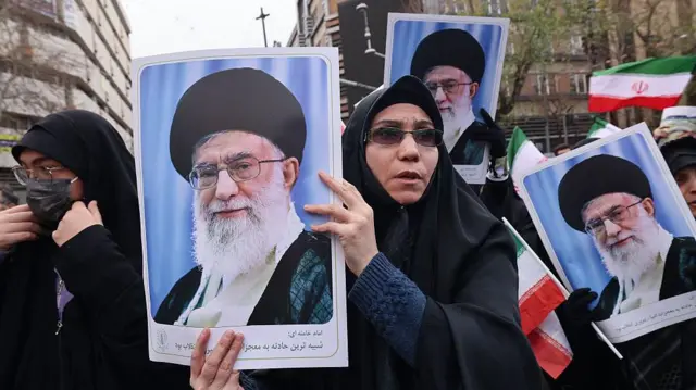 14 जनवरी 2026 को तेहरान में प्रदर्शनों के दौरान मारे गए सुरक्षा बलों के कर्मियों के अंतिम संस्कार के दौरान ईरानी महिलाएं ईरान के सर्वोच्च नेता आयतुल्लाह अली ख़ामेनेई की तस्वीरें थामे हुए. राज्य टीवी के मुताबिक़, 14 जनवरी 2026 को तेहरान में सुरक्षा बलों और अन्य 'शहीदों' के 100 से ज़्यादा सदस्यों के लिए अंतिम संस्कार समारोह शुरू हुआ, जो इस्लामी गणराज्य को हिला देने वाले विरोध प्रदर्शनों की लहर में मारे गए थे.