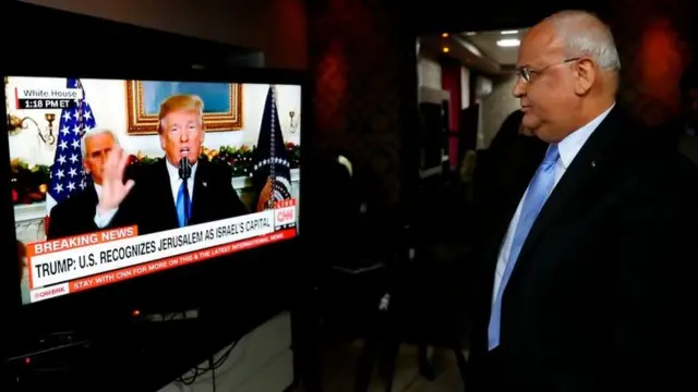 Saeb Erekat staring at Donald Trump on a screen