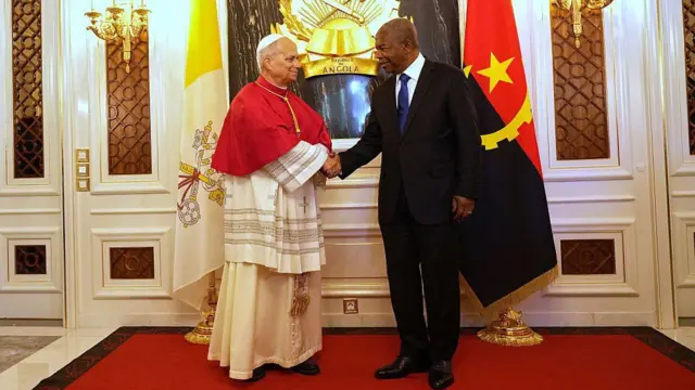 Popu Leo XIV (n'aka ekpe) na-ekwe Onyeisiala Angola Joao Lourenco (n'aka nri) n'aka mgbe ha abụọ nzukọrọ n'obí Onyeisiala na Luanda.