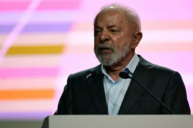 Lula usando terno e falando em um microfone na abertura da COP