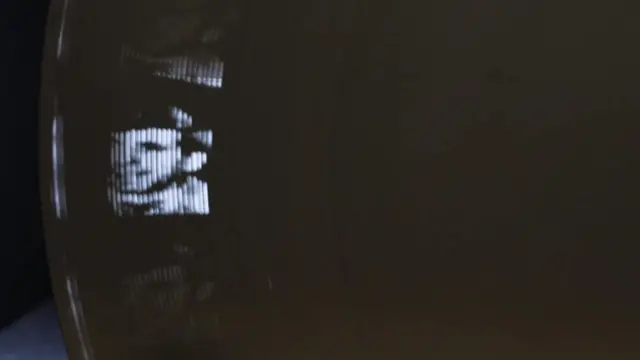 Una imagen parpadeante del dispositivo en acción con el rostro de un hombre visible en la luz.