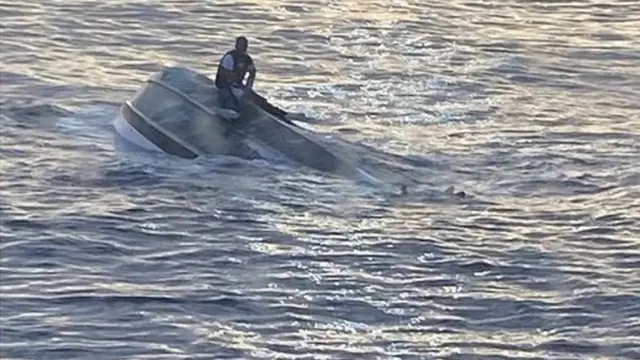 Juan Esteban Montoya sentadojogo de sinucacima do casco do barco virado no meio do mar