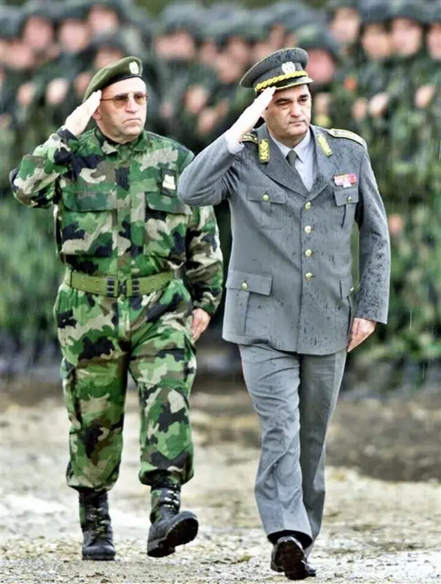 Muškarac u maskirnoj uniformi salutira, Pavković u svečanoj vojnoj uniformi takođe salutira