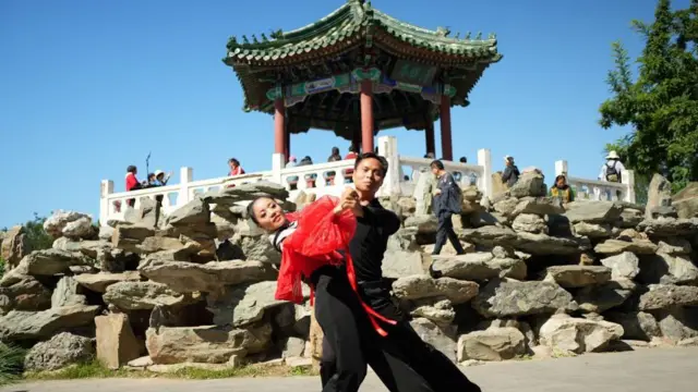 Dançarinos no Ritan Park,baixar aplicativo de apostafrente a um templo tradicional chinês.