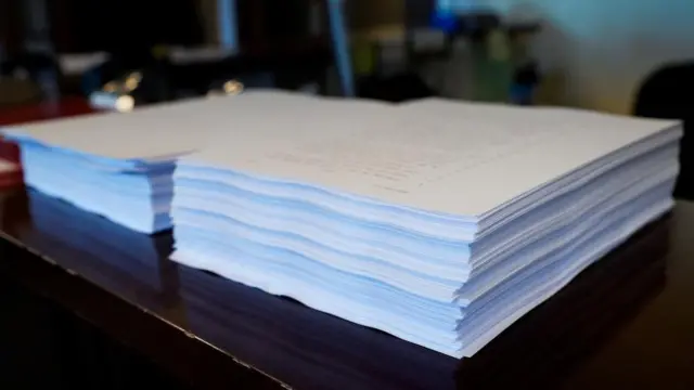 二つの大きい紙の山に分けて、上院職員の机に置かれた大型減税法案