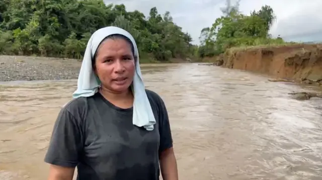 Perempuan dengan latar belakang banjir
