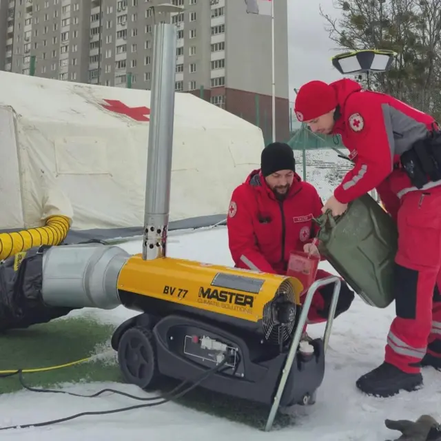 Двоє людей наливають паливо у генератор