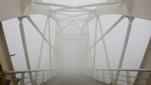 নদীর ওপর একটি ব্রিজ কুয়াশায় ঢেকে আছে 