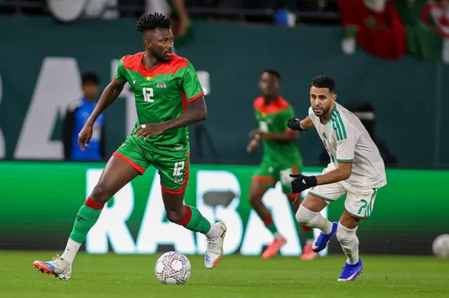 Edmond Tapsoba (Burkina Faso) tente d'échapper à la pression de Riyad Mahrez (Algérie) lors du match de Coupe d'Afrique des Nations (Groupe E) opposant l'Algérie au Burkina Faso, au stade Moulay Hassan, le 28 décembre 2025 à Rabat, au Maroc.