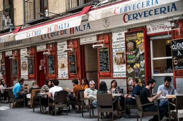 Foto colorida mostra mesas na calçadaapostar na copa do mundoum bar 