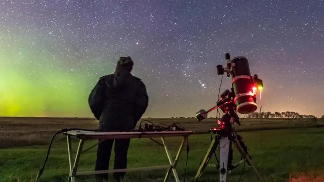 Pessoa observa o céu à noite ao ladoslots bonus de cadastroluneta