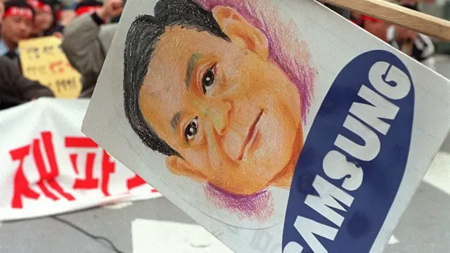 Cartel con el dibujo de Lee Kun-hee en unas protestas contra la compañía.