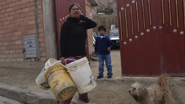 Mujer con varios cubos de agua