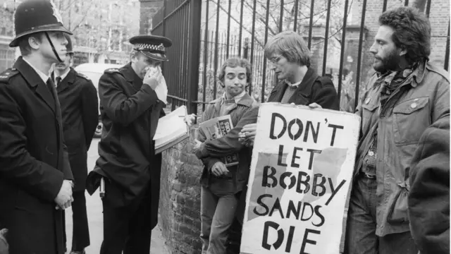 Manifestante segura placa em que se lê 'Don't let Bobby Sands die'
