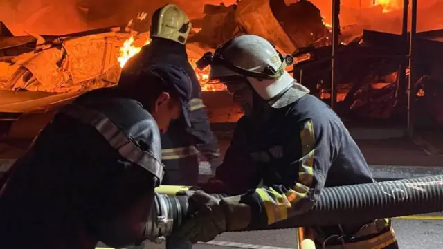 Троє пожежників гасять пожежу
