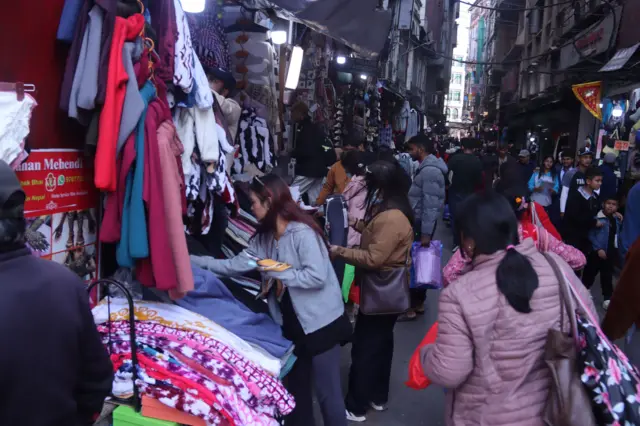 बजारमा किनमेल गर्दै मानिसहरू