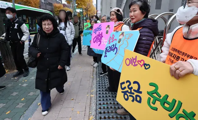 13일 오전 서울시교육청 12지구 제22시험장인 서울 마포구 홍익대학교사범대학부속여자고등학교에서 일성여자중고등학교 최고령 수험생 서혜숙(78) 씨가 학우들의 응원을 받으며 시험장으로 향하고 있다