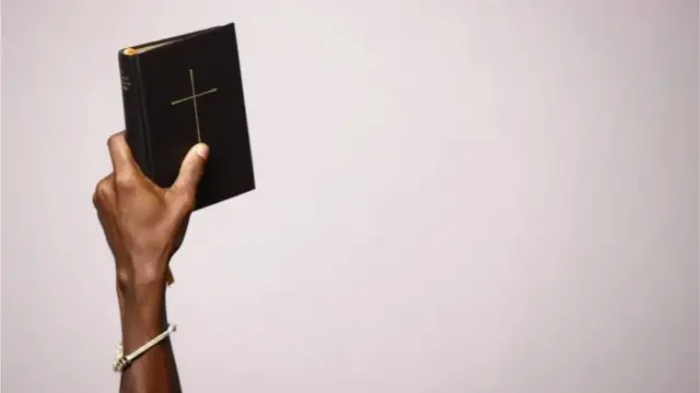Mão segurando uma Bíblia