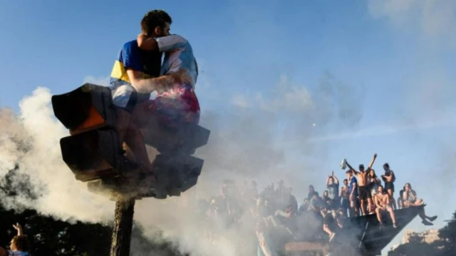 Экрандарда эмне болуп жатканын жакшыраак көрүү үчүн адамдар жол чырактарга жана мамычаларга да чыгышкан.