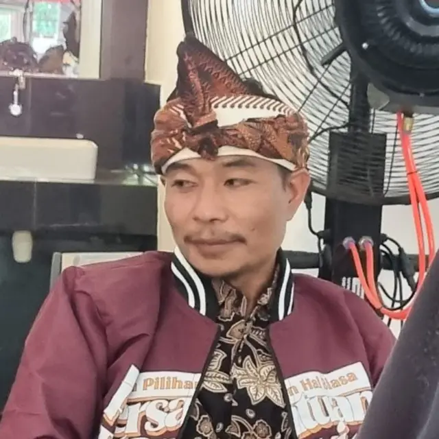 Seorang pria menggunakan pakaian adat Masyarakat Bayan di Lombok Utara.