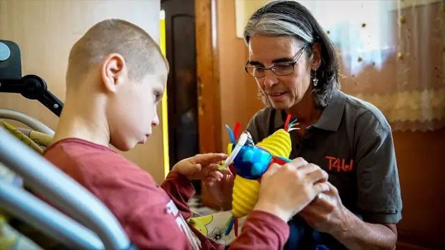 الممرضة المتخصصة روث وين ويليامز مع أحد الأطفال في ماغالا