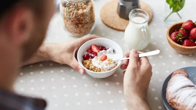 Un homme devant un bol de nourriture.