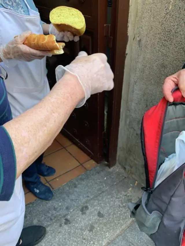 Unas manos con un trozo de pan y una mochila abierta