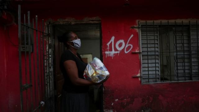 Miriam dos Anjos em entre em sua casa após receber alimentos da CUFA (Central Única de Favelas)
