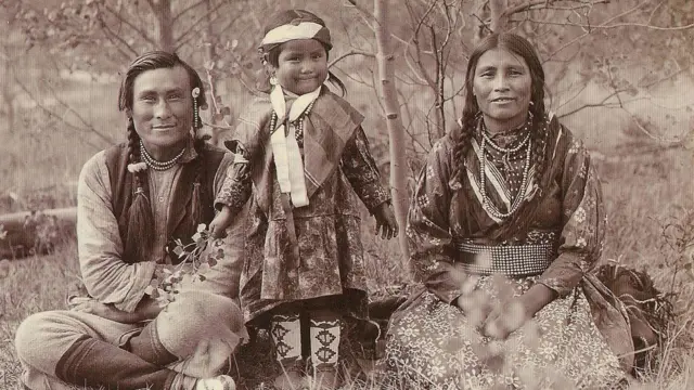 Родини індіанців - чоловік, жінка та дитина в традиційному вбранні на природі. Фото сепія