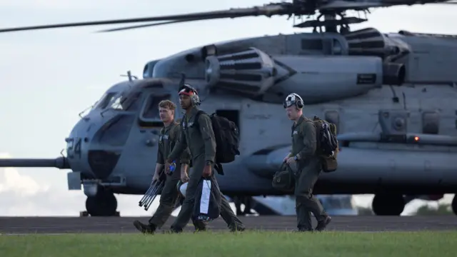 un grupo de soldados camina junto a un helicópero en una base militar en Ceiba, en el este de Puerto Rico. 