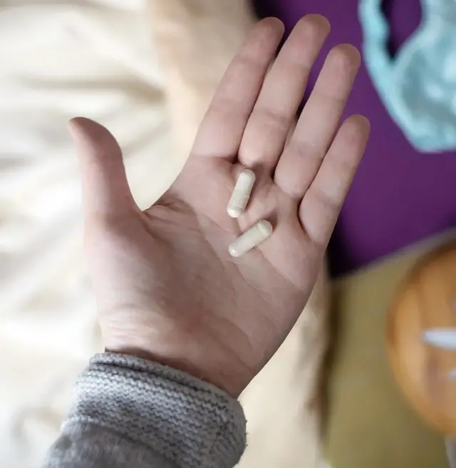 Un homme tient des comprimés sur sa main