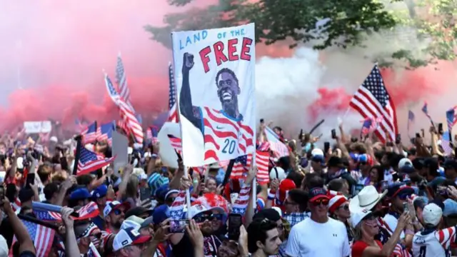 مشجعو المنتخب الأمريكي يحملون صورة المهاجم فولارين بالوغون قبل مواجهة بلجيكا الليلة
