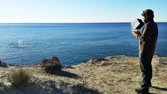 Fredrik Christiansen frente al mar operando un dron