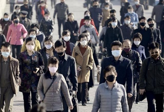 People wearing protective face masks commute amid concerns over the new coronavirus disease (COVID-19) in Pyongyang, North Korea March 30, 2020
