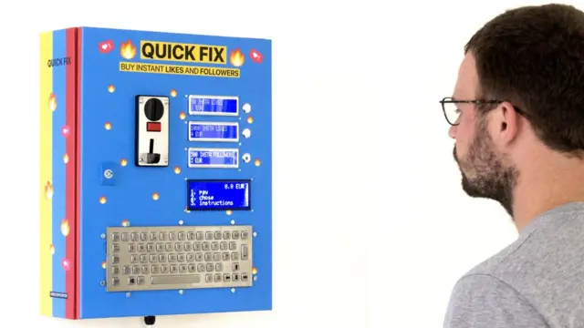Dries Depoorter debout devant son appareil "Quick Fix" qui distribue des J'aime et followers