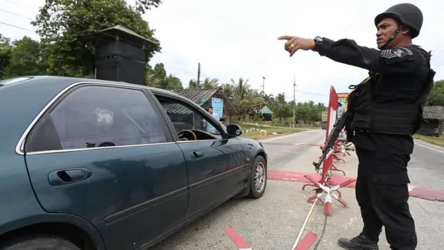 ทหารกำลังตรวจรถยนต์ที่ขับผ่านด่าน