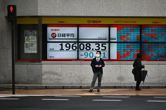 Un ciudadano con mascarilla frente a la Bolsa de Tokio en Japón el 10 de marzo de 2020.