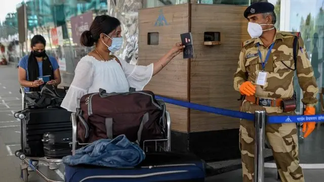 Mulher mostra o passaporte a um guardajogo butterfly kyodai grátissegurançajogo butterfly kyodai grátisum aeroporto