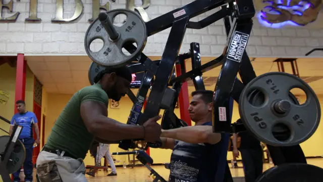 Homens praticando musculação em academia