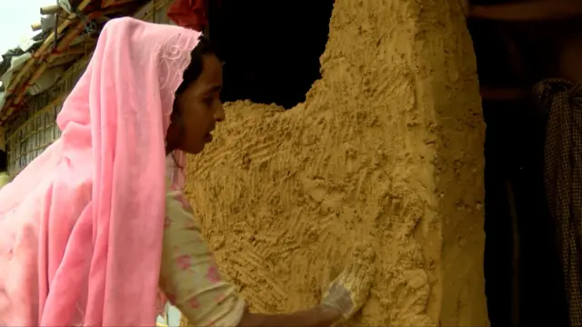 কাঁচা মাটির দেয়াল তুলে বসতঘরকে আরেকটু আরামদায়ক করার চেষ্টা ফাতেমা বেগমের।