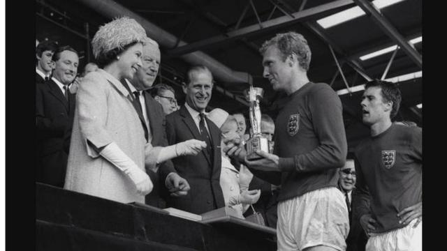 Легенда английской сборной Бобби Мур получает кубок мира из рук королевы Елизаветы II