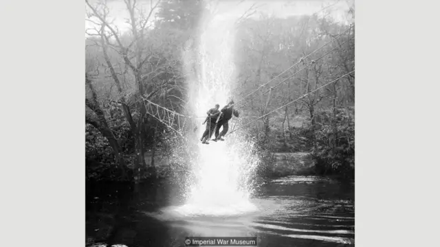 Британские "коммандос" переправляются через реку под учебным артиллерийским огнем в учебно-тренировочном лагере в шотландском городке Акнакарри (январь 1943 года)