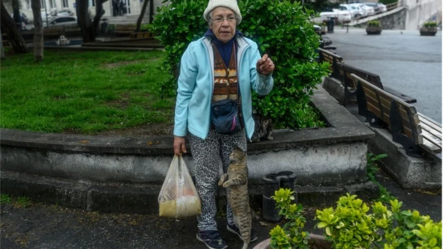 жена с кесом у руци и мачка