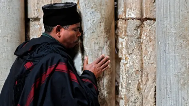 Ni Jerusalem, lorilẹede Israel, onigbagbọ kan lati Etiopia n gbadura nibi ilẹkun ti ẹnu ọna ṣọọṣi Sepulchure mimọ.