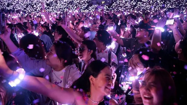 Sejumlah penonton menyaksikan konser grup band asal Inggris, Coldplay di Stadion Utama Gelora Bung Karno (SUGBK) Senayan, Jakarta
