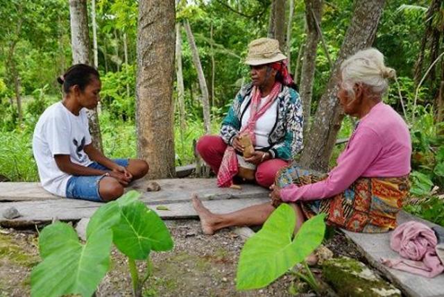 Mama Aleta terlibat diskusi dengan dua orang warga setempat.