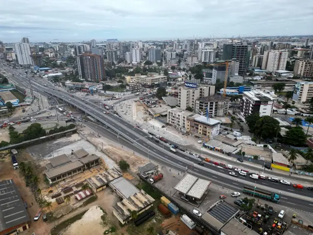 Une vue d'en haut d'une partie de la ville d'Abidjan, avec une grande route au milieu des immeubles
